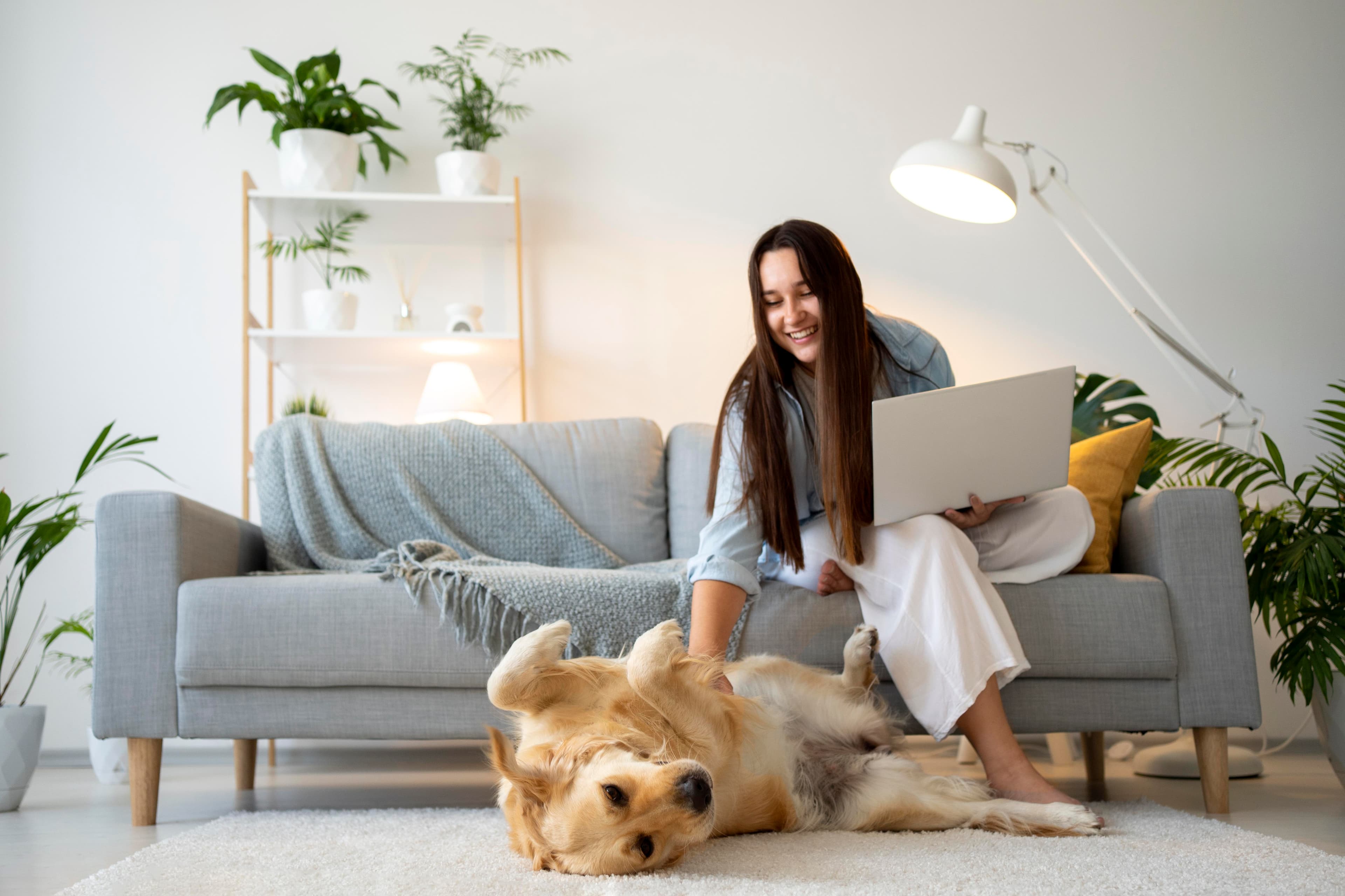 Mulher brincando com cachorro dentro de sua casa.